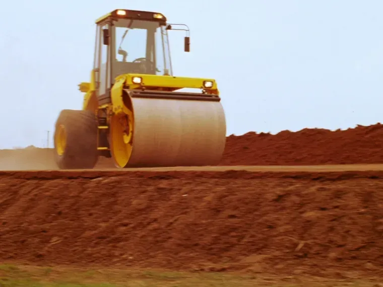 Compactação de camada de aterro com rolo vibratório, com a umidade ajustada antes da passada.